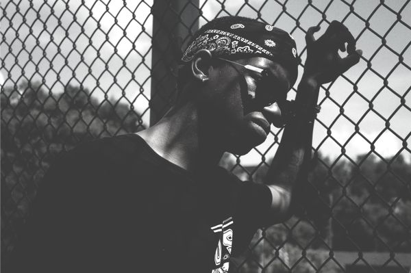 man leans on wire fence